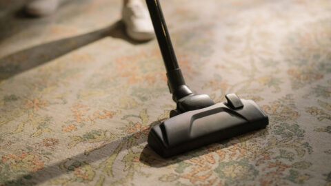 A vacuum cleaner head on a patterned floral carpet