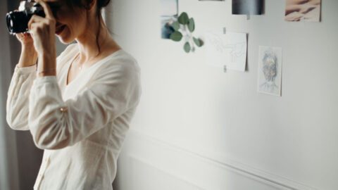 Woman taking a photo indoors with artistic decorations on the wall