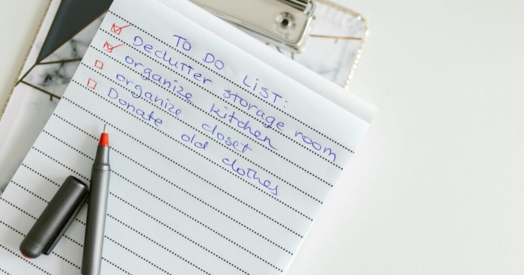 A neatly written to-do list on lined paper with a pen, perfect for organising tasks