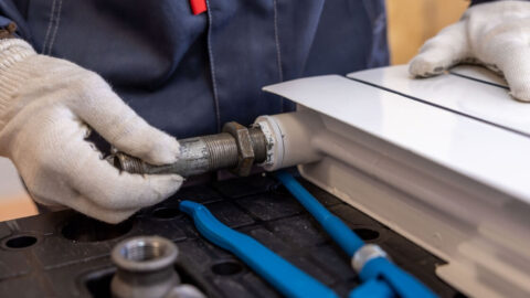 The hand of a plumber repairing a pipe