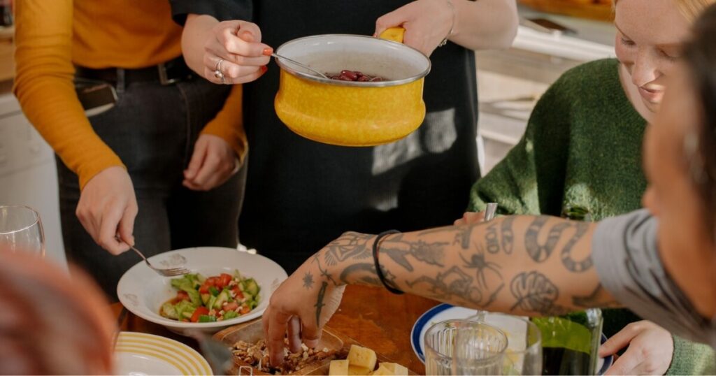 A group of friends enjoying a veggie meal together in a bright kitchen setting