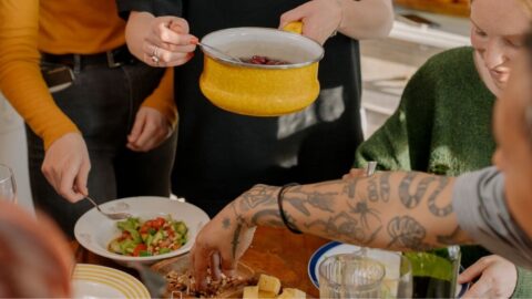 A group of friends enjoying a veggie meal together in a bright kitchen setting