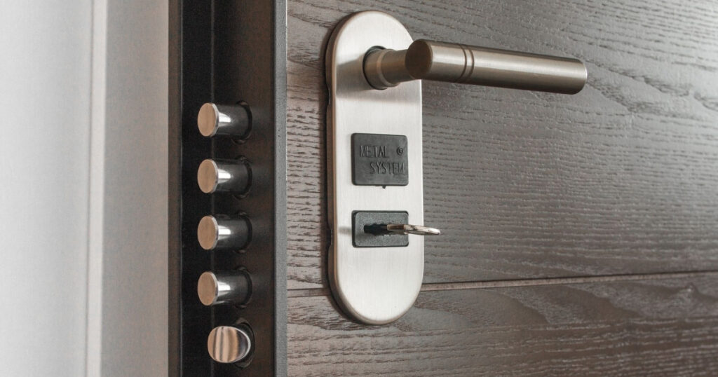 Metal door handle and lock system with key inserted, showcasing security features