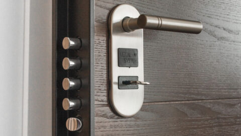 Metal door handle and lock system with key inserted, showcasing security features