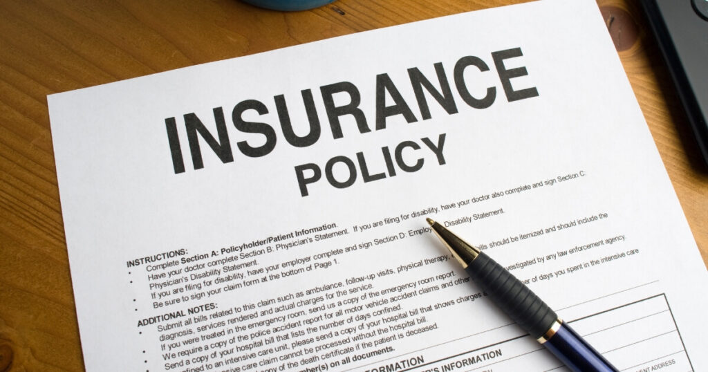 Close up of a printed insurance policy with a pen resting on top