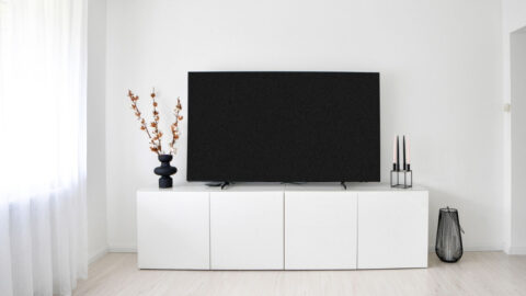 A sleek and minimalist Scandinavian living room with white decor and electronics