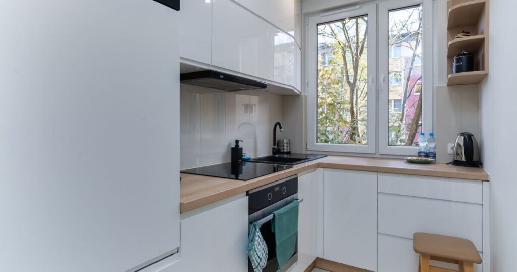 Bright and clean minimalist kitchen with white cabinetry and natural light