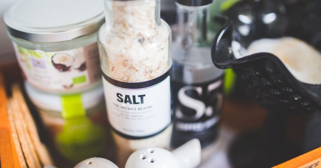 Close-up view of various kitchen condiments, featuring salt shaker and other containers