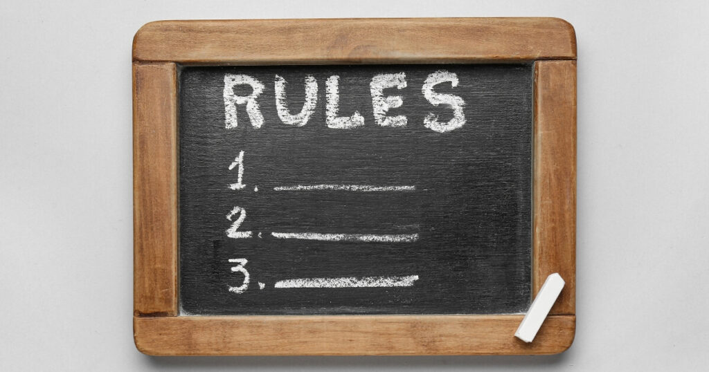 A chalkboard with a wooden frame with the title Rules and numbered one, two, and three